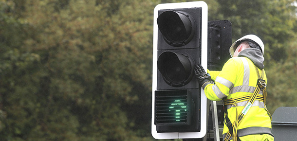 Council worker attending to road traffic lights - the signal illuminated is a green forward arrow